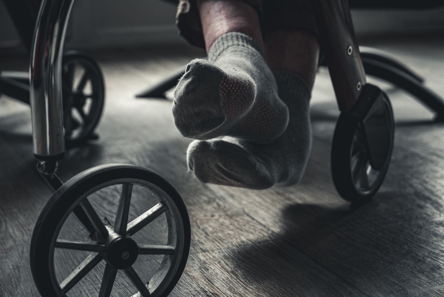 Voeten en wielen van een rollator in laag invallend licht